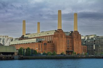 Vista externa da Battersea Power Station, às margens do rio Tâmisa, sob céu nublado em Londres.